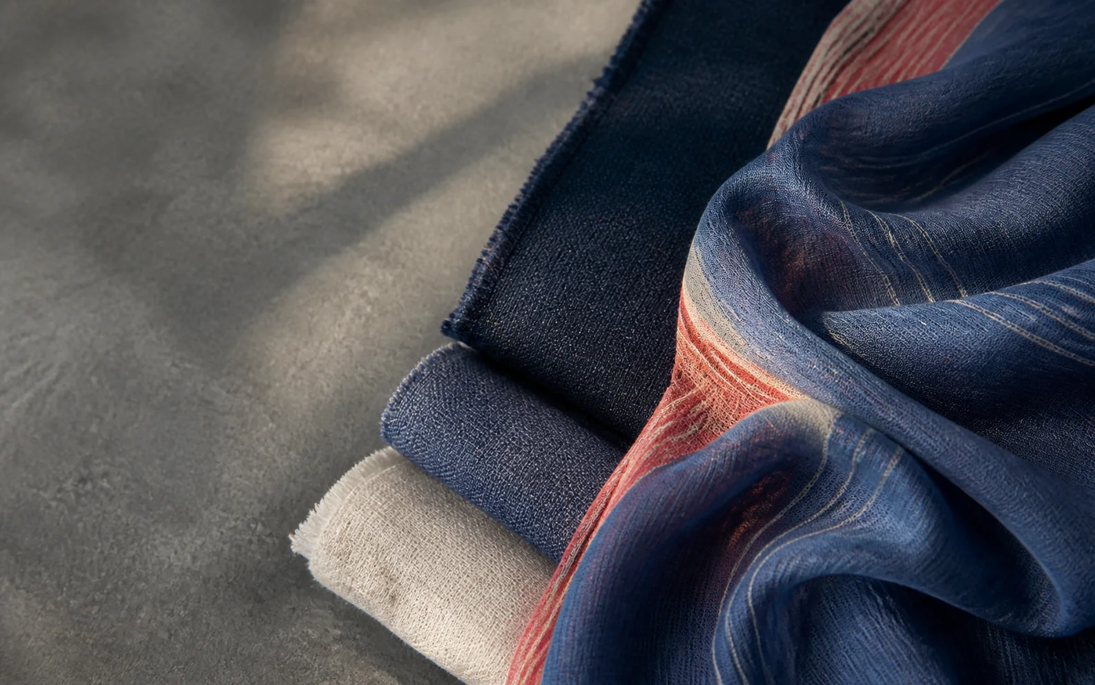 Close editorial study of layered indigo and coral woven textiles